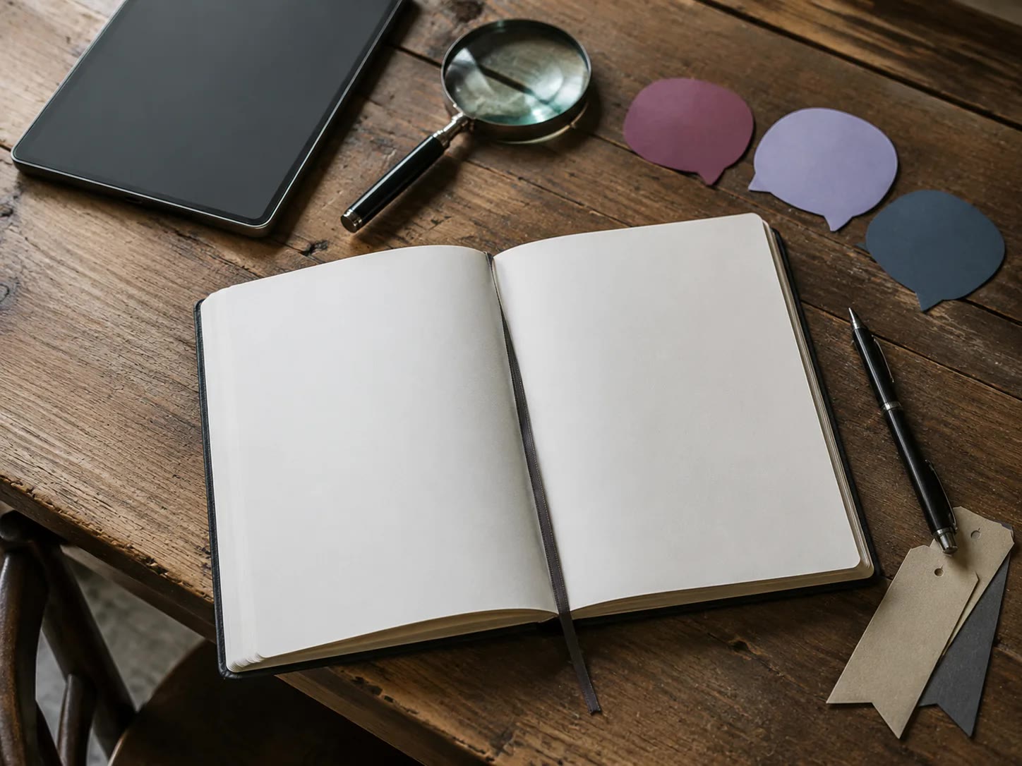 Table de recherche avec carnet, cartes de dialogue, loupe et stylo